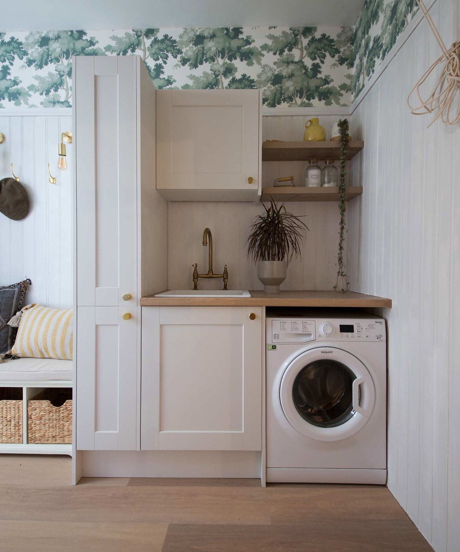 Industville Sleek Edison Wall Light - Brass image &amp;ndash; a neutral laundry room with green and white wallpaper, and an entryway bench to the left