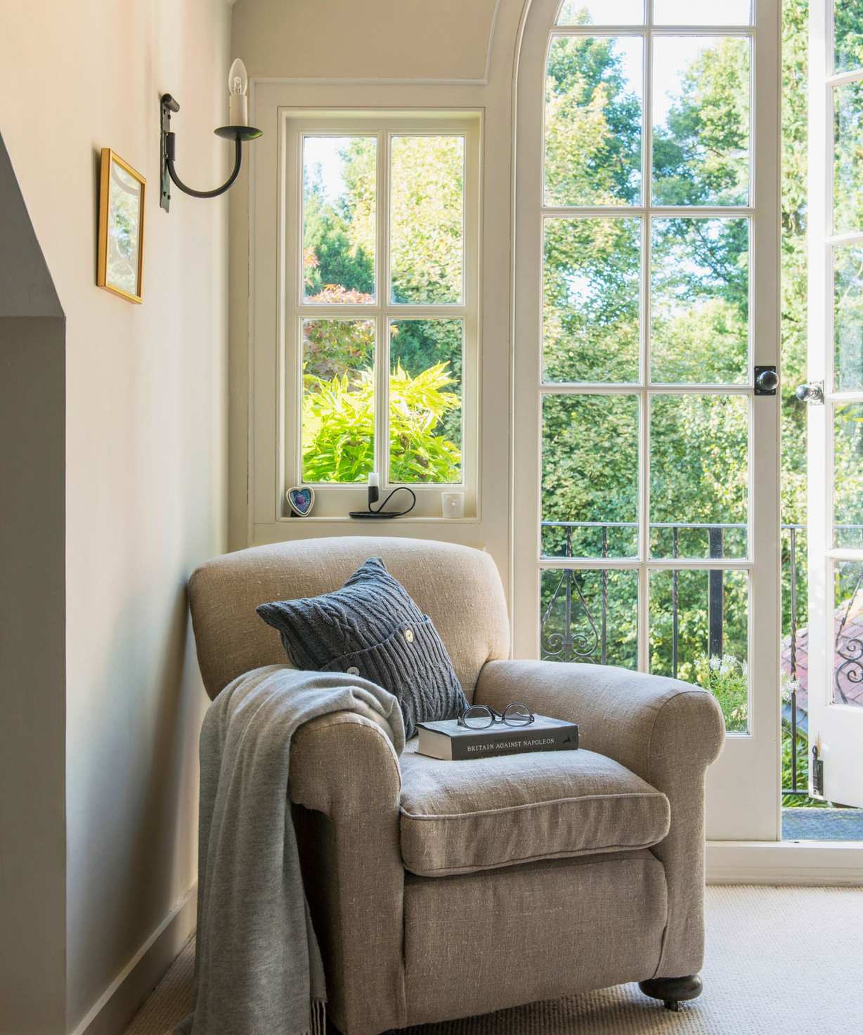 An armchair by a window in a bedroom.