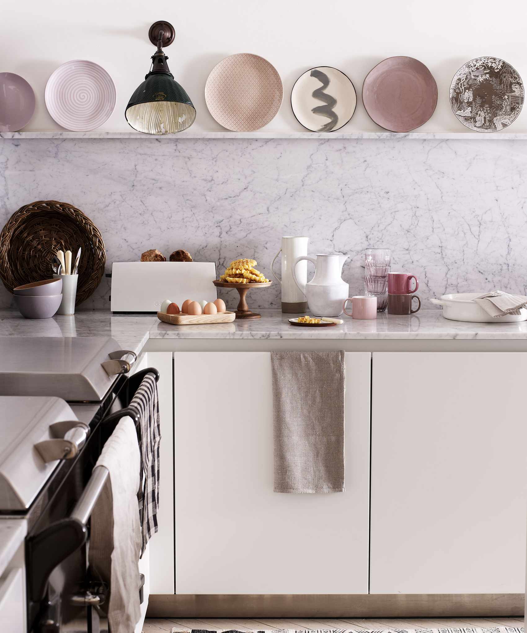 Kitchen wall lighting ideas with black wall downlight in a white kitchen with pastel pink accents.